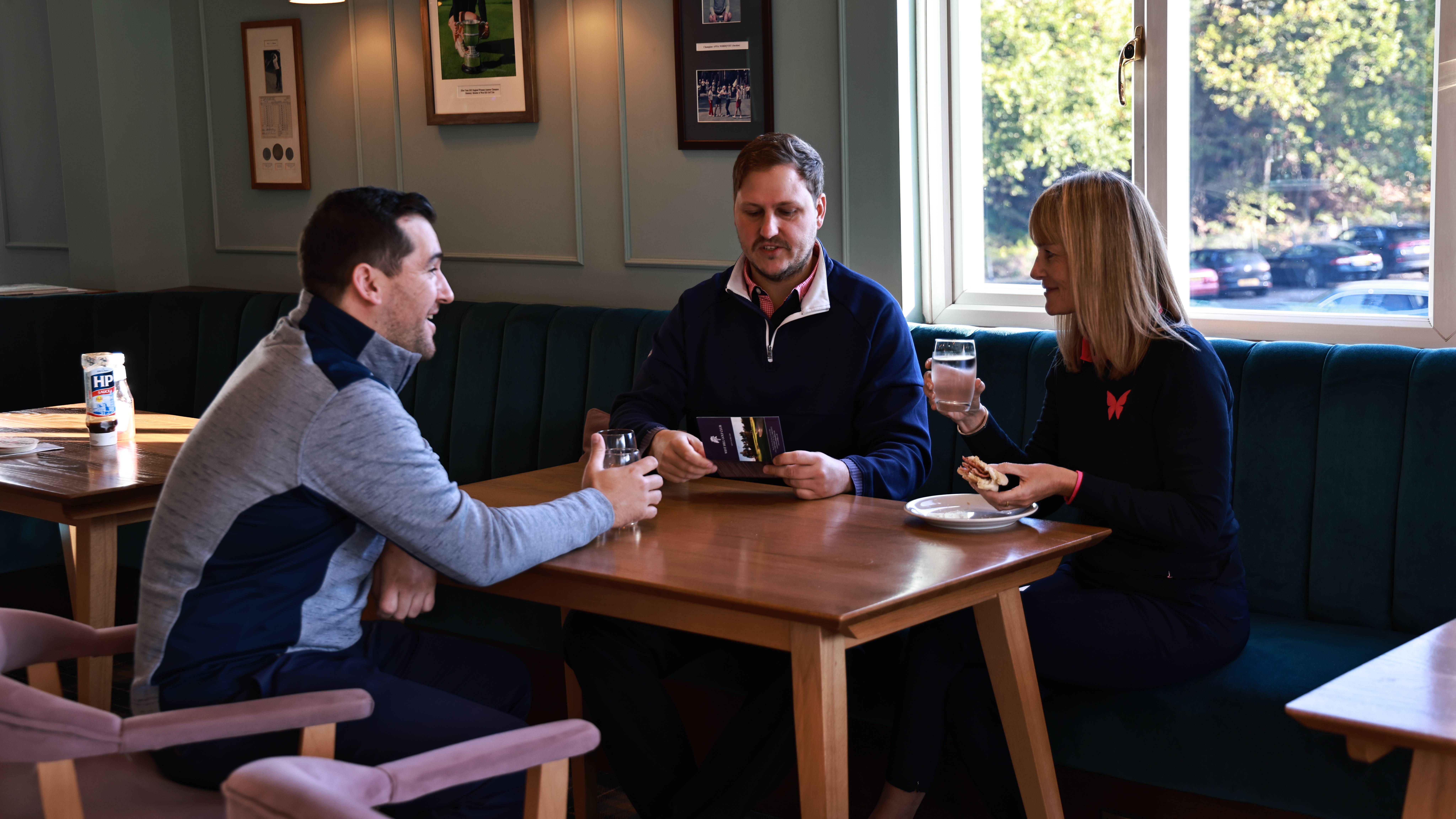 Male and female golfers sitting at golf club