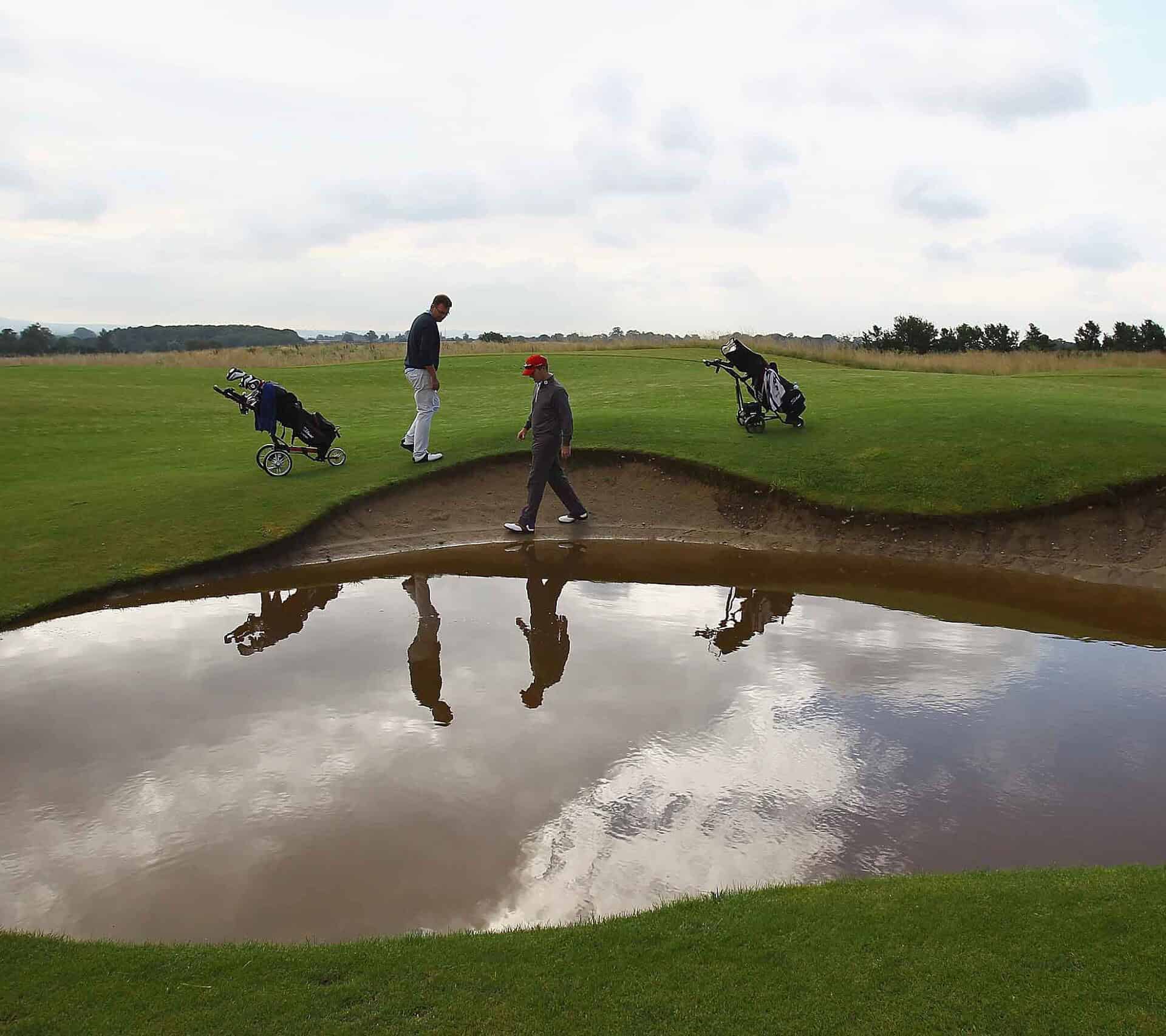 Can a round still count for handicap if bunkers are flooded? – National Club Golfer John Jacobs (L) of Cumberwell Park Golf Club looks for his ball in a flooded bunker with Richard Dinsdale of Parc Golf Academy during the Lombard Challenge Regional Qualifier at Cumberwell Park Golf Club on August 6, 2012 in Bath, England