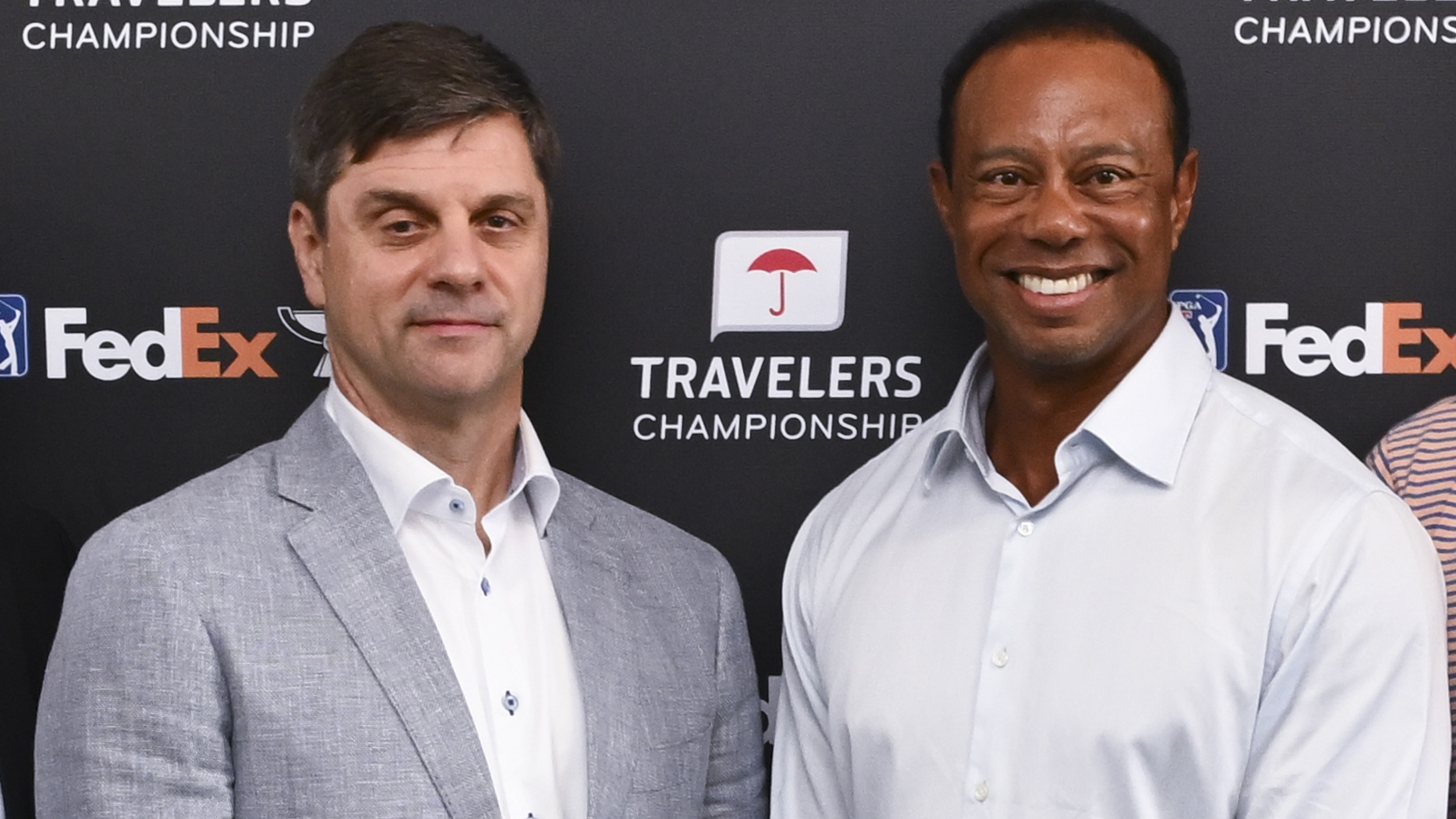 PGA Tour CEO Brian Rolapp standing alongside Tiger Woods