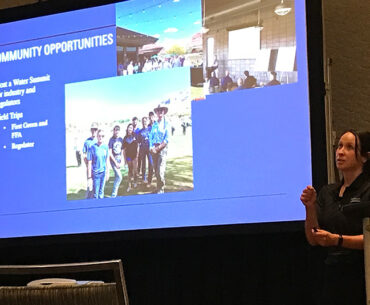 Woman speaking in front of a group of people in a conference room