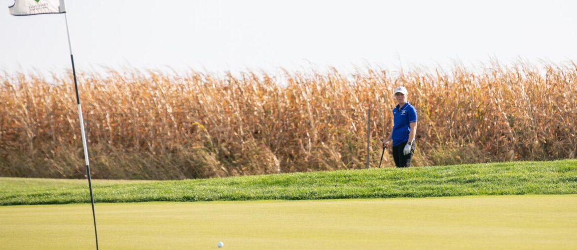 A women's golfer putts across the green during competition
