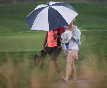 Fans walk in the rain along the fifth hole during the third round of the Arnold Palmer Invitational at Bay Hill golf tournament Saturday, March 7, 2026, in Orlando, Fla. (AP Photo/Matt Slocum)