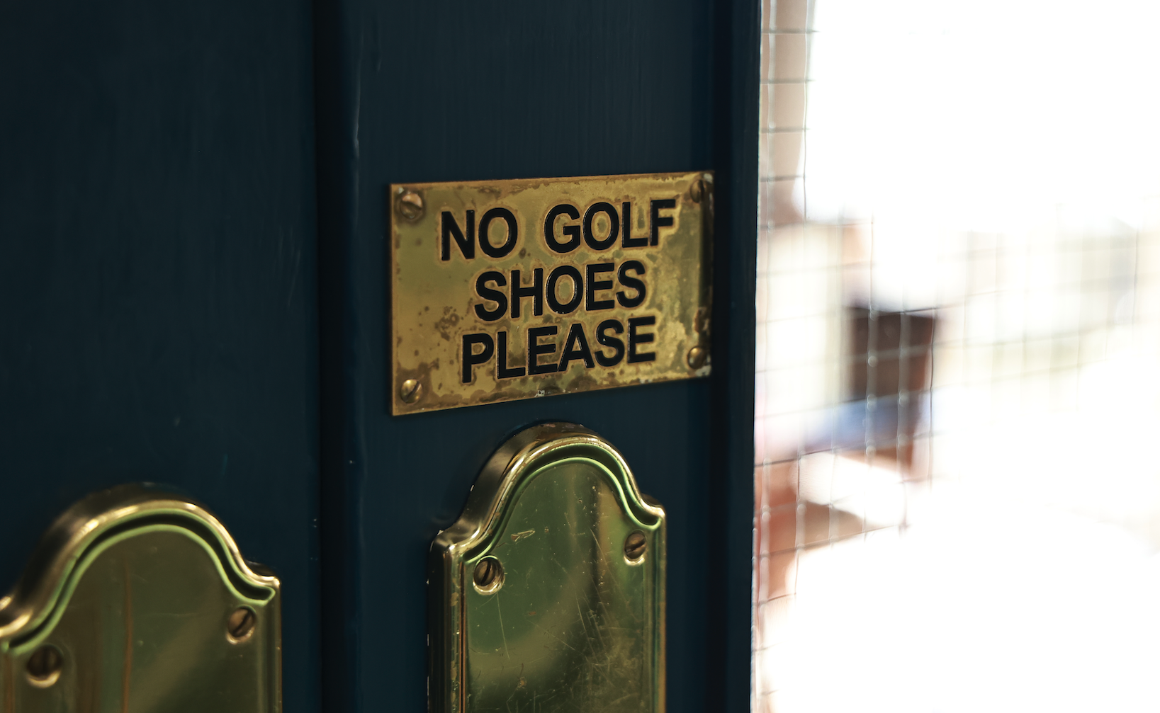 A No Golf Shoes Please sign on a door