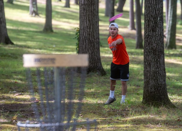 Max Tomaiuolo of Glastonbury throws his disc toward the basket on the third hole while playing the 9-hole course with his friend Nick Traver at the Center Springs Park Disc Golf Course in Manchester on Monday, Sept. 8, 2025. The two took advantage of the comfortable weather for a round of disc golf. (Aaron Flaum/Hartford Courant)
