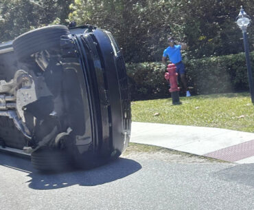 Golfer Tiger Woods stands by his overturned vehicle in Jupiter Island, Fla., on Friday, March 27, 2026. (AP Photo/Jason Oteri)