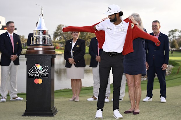 Akshay Bhatia of the United States dons the iconic red cardigan sweater after winning the Arnold Palmer Invitational.