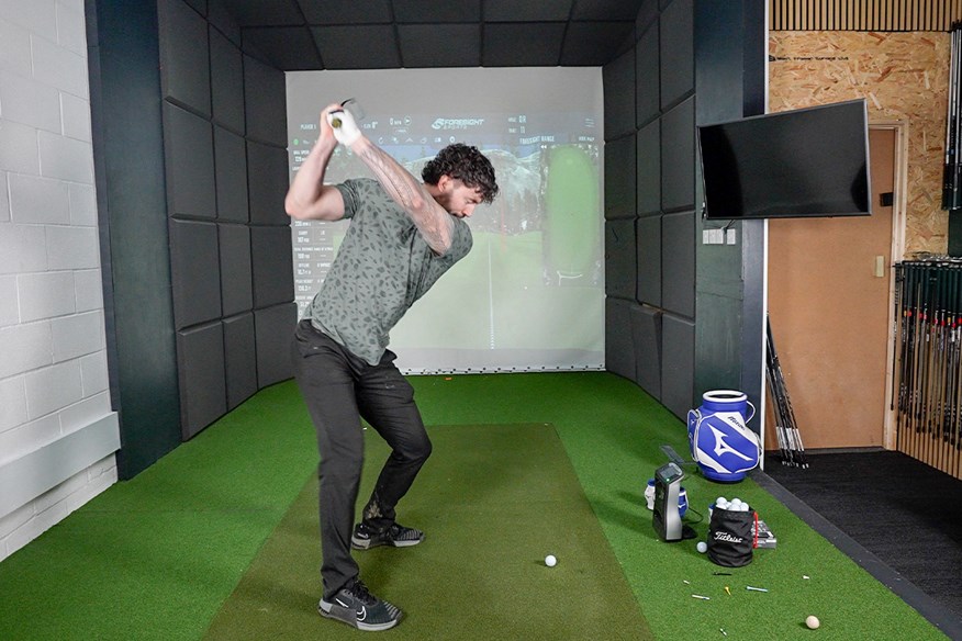 hitting the ping i540 players' distance iron inside at custom golf works to gather data