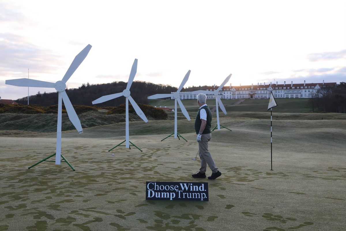 Handout photo issued by Greenpeace of a wind farm installed by Greenpeace activists on a green of the Trump Turnberry Golf Club, together with a sign reading 'Choose wind, dump Trump'. Greenpeace said three people set up six small mock-up wind turbines on the fourth hole green at the club in South Ayrshire at about 6.30am on Monday. The activists said their demonstration came in response to the US president's dislike for wind turbines and his support for oil and gas energy. Issue date: Monday April 20, 2026.