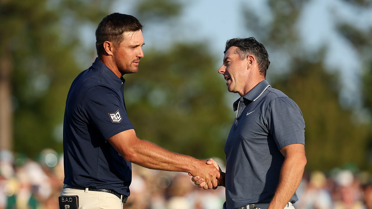 Rory McIlroy shaking hands with Bryson DeChambeau on the 18th hole at Augusta National Golf Club