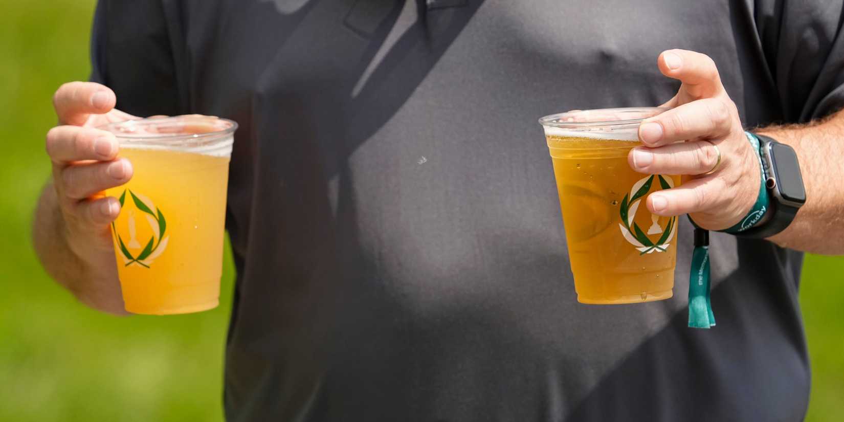 Golf fan carries two beers