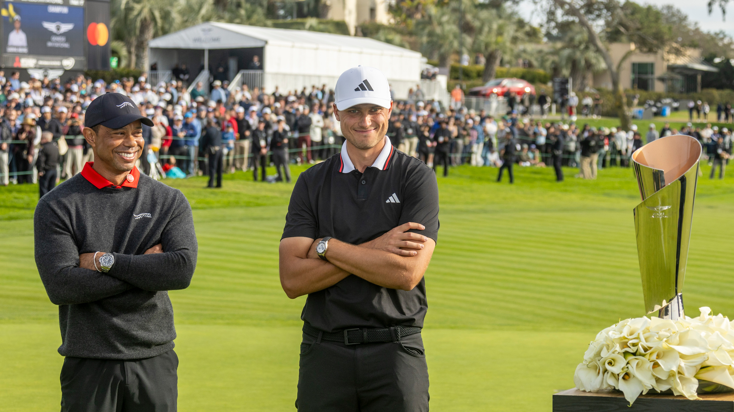 Tiger Woods (left) and Ludvig Aberg cross their arms and smile while looking on at the Genesis Invitational trophy after the Swede's win in 2025