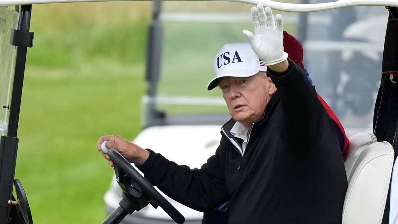 Former President Donald Trump waves to reporters while driving a golf cart at the Trump Turnberry golf course in Turnberry, Scotland. (Photo: AP, Yonhap News)