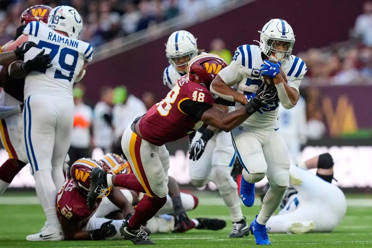 Indianapolis Colts running back Jonathan Taylor (28) is tackled by Washington Commanders linebacker Joshua Josephs (48) during an NFL football game in London, Sunday, Oct. 4, 2026. (AP Photo/David J. Phillip)